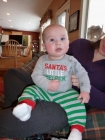 His other grandma gave him the darling sleeper with the darling feet. I game him the \'Santa\'s Little Helper\' outfit which you can see  has already been slightly spit up upon. :)