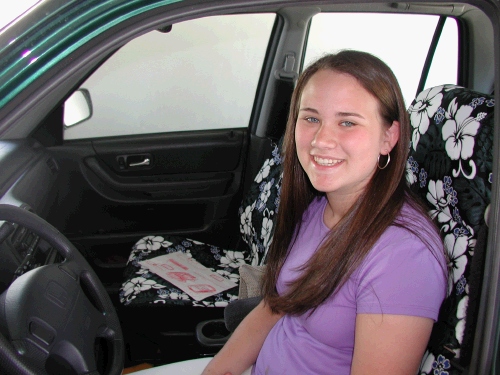 Tess ready to drive off on her own with her new driver's license and new Hawaiian seat covers!