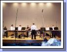 The whole percussion ensemble playing together.  Elliot is in the center back with the "keytar" and Clark is on the far right playing the marimba.